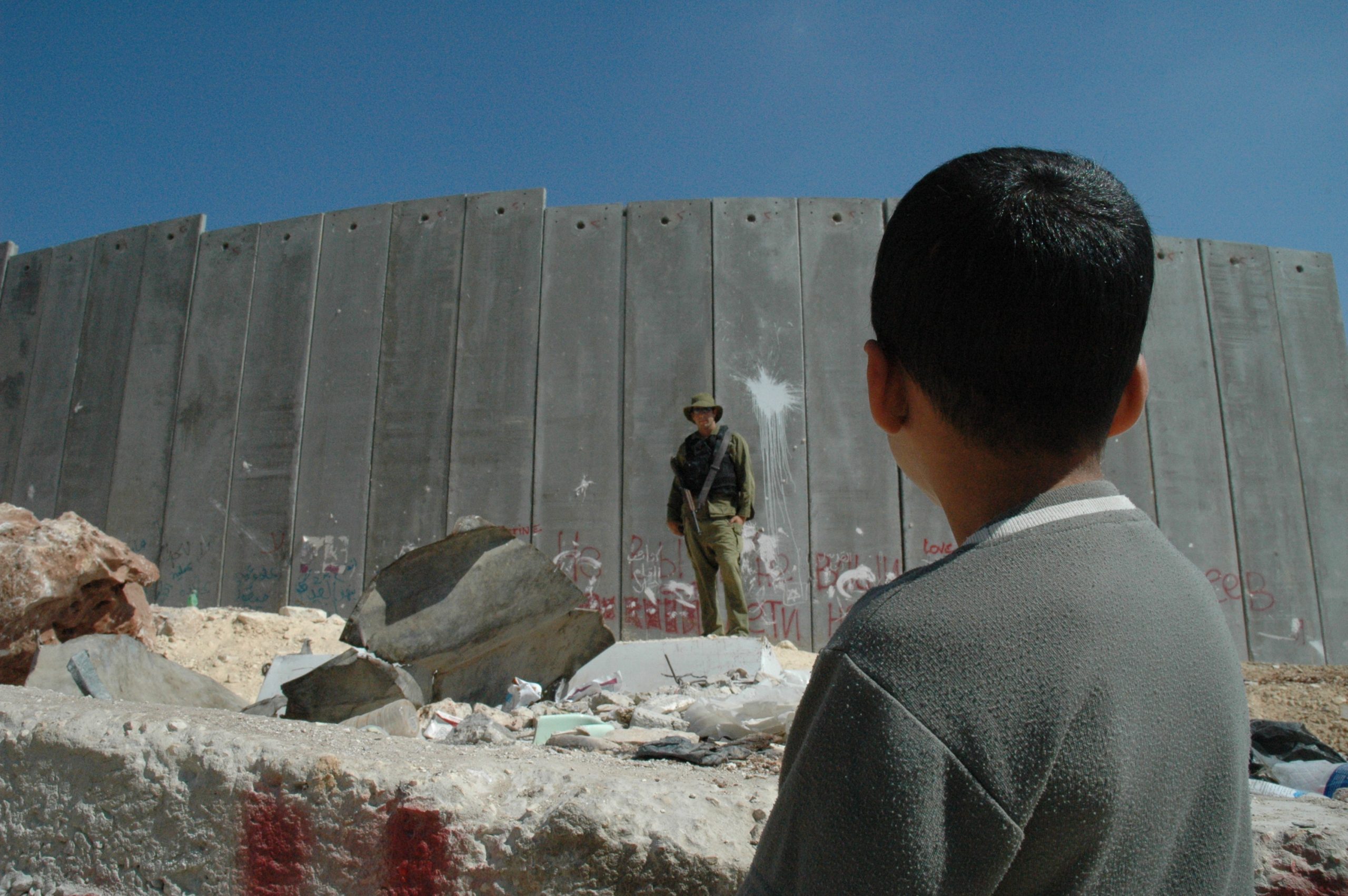 boy_and_soldier_in_front_of_israeli_wall_justin_mcintosh