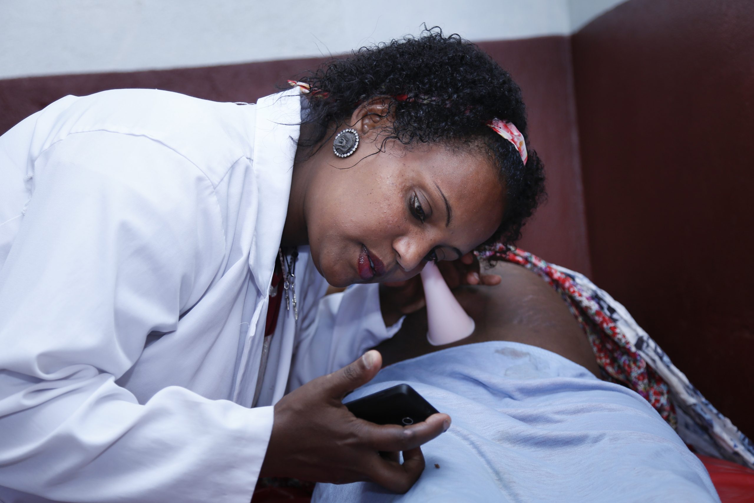 photo_5_-_midwife_zinash_examines_woman_w_phone