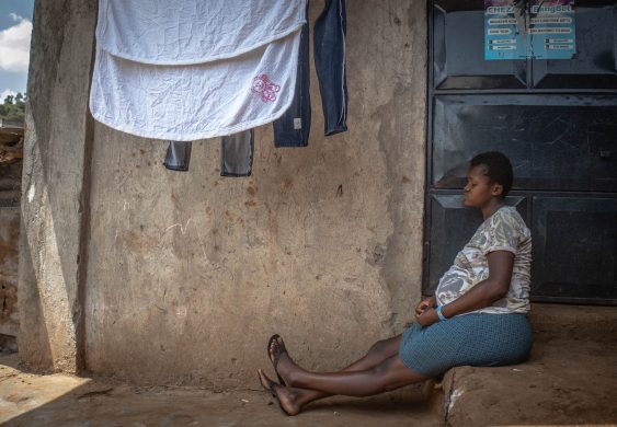 Gravid afrikansk kvinde sidder ned
